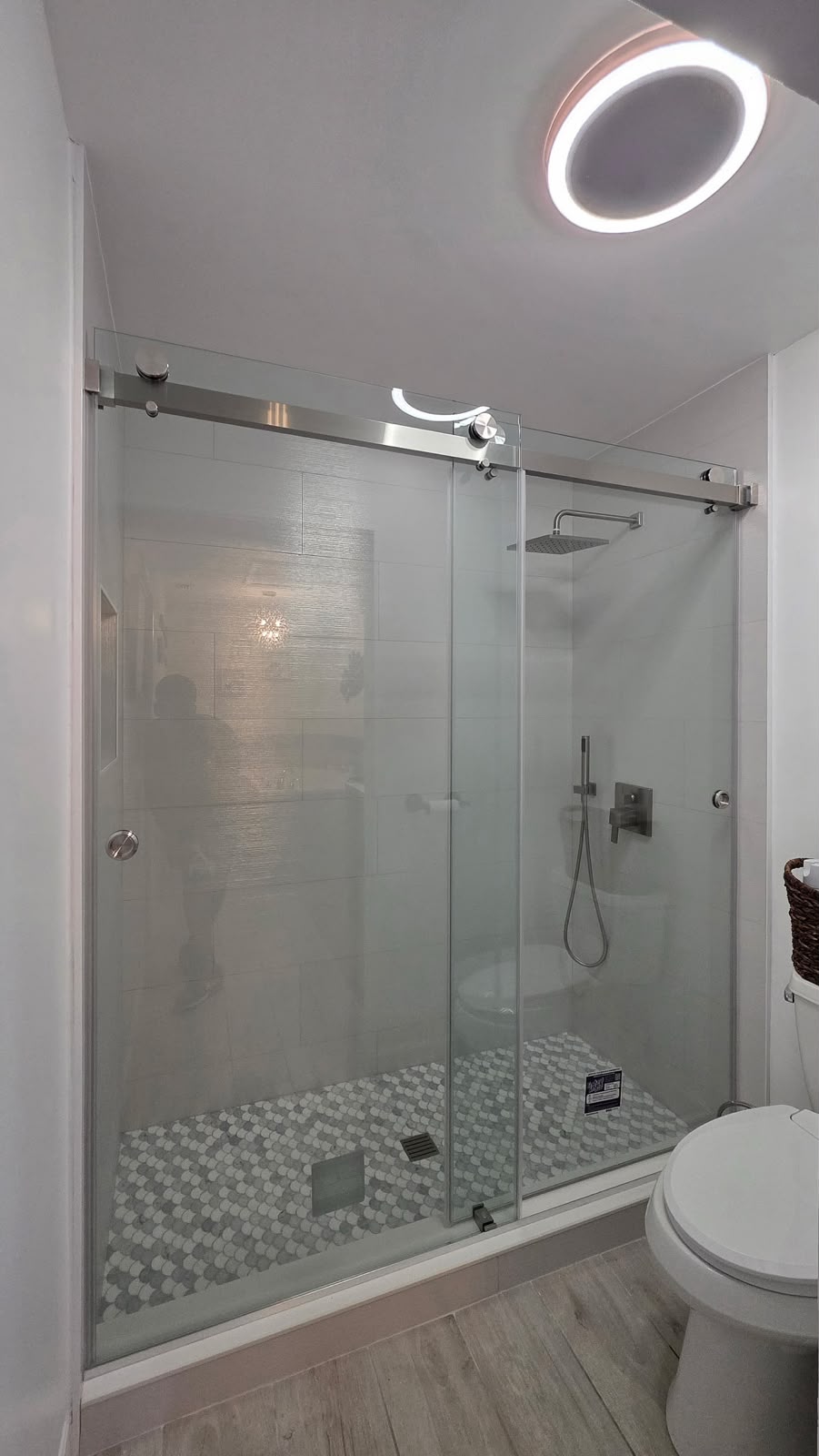 Completed bathroom shower with sliding glass doors and tile flooring