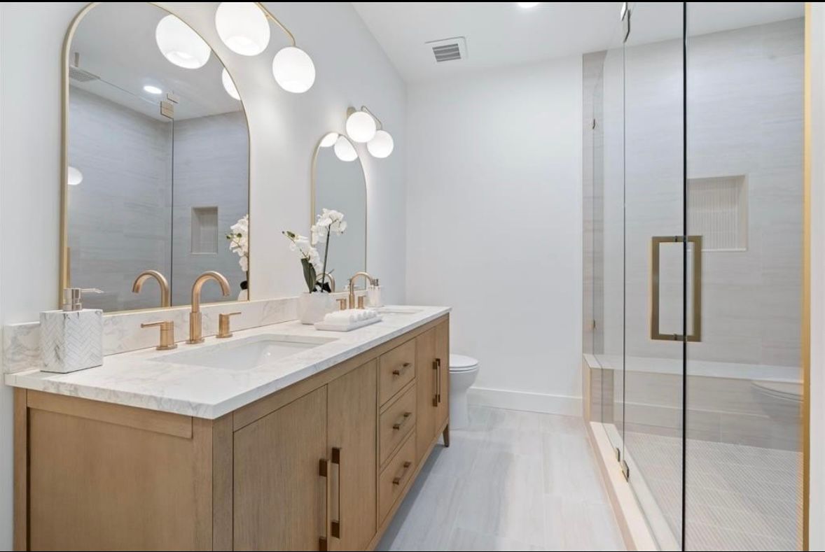 Renovated bathroom with warm fixtures and glass shower